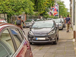 Geparkte Autos verbrauchen ein hohes Gut: den Platz im öffentlichen Raum. Besonders beim „Gehweg­parken“ behindern und gefährden sie zudem andere Verkehrs­teilnehmer. Merheimer Straße, Köln-Nippes Foto: Gregor Theis