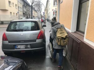 Rullstuhlfahrer auf einem blockierten Gehweg 