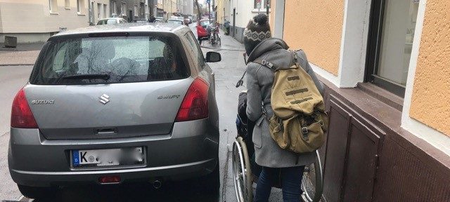 Rullstuhlfahrer auf einem blockierten Gehweg